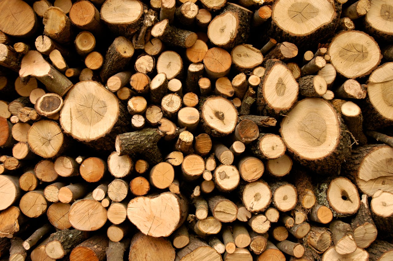 A neatly stacked pile of natural cut firewood, perfect for rustic themes and environmental concepts.